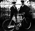 Jules et Paul Cornu avec le vélo à moteur qu'ils ont conçu et construit à Lisieux, en 1898.