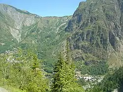Vue de l'adret du col de l'Alpe que franchit la télécabine entre le village de Venosc (à gauche derrière les arbres) et l'Alpe de Venosc.
