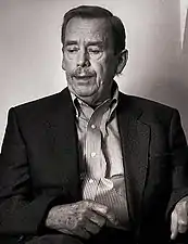 Portrait photographique noir et blanc d'un homme âgé, le regard porté hors du cadre et portant un costume sans cravate.