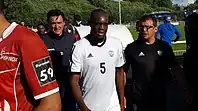 Sortie des joueurs et des entraîneurs après un match de football.