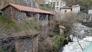  photo en automne du bâtiment d'une ancienne coutellerie en aval de l'usine du Creux de l'enfer. La bâtisse sur 2 niveaux en pierres de schistes brunes vient d'être en partie restaurée, sa toiture de tuiles est neuve mais il n'y a encore aucune huisserie aux fenêtres