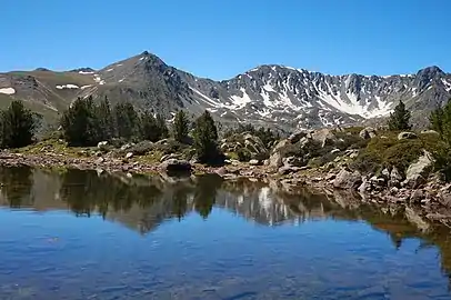 Blocs de granite au premier plan (estany de la Bova) et crête sud de la vallée du Madriu formée de sommets granitiques à l'arrière-plan.