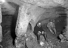 Photo en noir et blanc de deux hommes assis dans un tunnel.