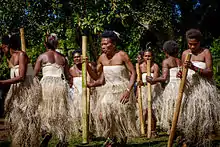 Photographie représentant un groupe de femmes dansant en tenues traditionnelles.