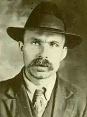 Photo d'un homme à moustache avec un chapeau.