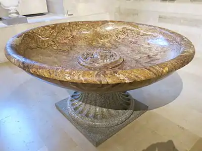 Fontaine romaine monolithique en marbre avec une tête de Méduse, au musée du Louvre.