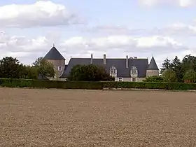 Photographie en couleurs d'un long édifice dont la façade est rythmée de tours rondes.