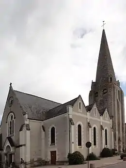 Photographie d'une église avec un haut clocher tout en pierres.