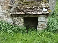 Vue rapprochée de l'appentis abritant la fontaine.