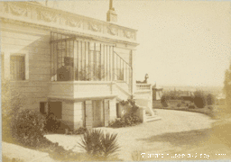 Photographie ancienne d'une villa avec façade moulurée et véranda.