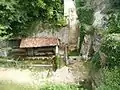 Le site, avec la fontaine et la grotte à droite.