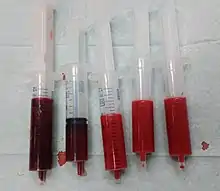 Cinq seringues remplies de sang sont présentées. Deux contiennent un sang rouge sombre d'origine veineuse et trois un sang rouge vif d'origine artérielle.