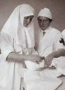 Photographie en noir et blanc de deux femmes en blouse d'hôpital.