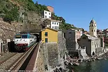 Train Intercity à destination de Milan passant au niveau du bâtiment voyageurs de l'ancienne gare de Vernazza.