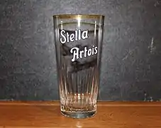 Vieux verre à bière "Stella Artois" avec écriture émaillée.