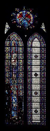 Verrière en deux lancettes de 45 panneaux vitrés. La lancette de droite est faite de verre blanc. La lancette de gauche, en verres de couleur en partie noircies, représente deux saints.
