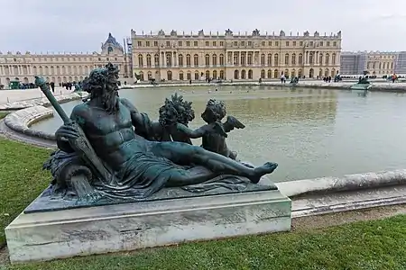 Margelle de fontaine ornée d'un bronze.