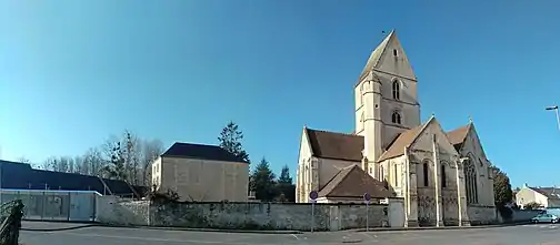 L'église Saint-Germain. À gauche, Les Ateliers de l'Odon sont une ancienne usine du XIXe transformée en un lieu qui accueille des associations.