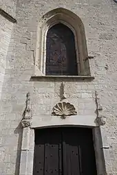 Entrée de l'église Saint-Pierre, surmontée d'une coquille Saint-Jacques.