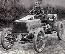 Photo d'une voiture avec son pilote au volant.