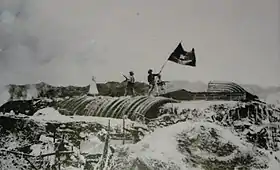 Vue éloignée de soldats sur le champ de bataille, brandissant le drapeau vietnamien.