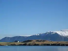 Viðey vu depuis Reykjavik avec l'Esja en arrière-plan.