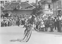 Photographie en noir et blanc d'un cycliste en course.