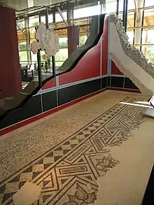Photographie d'une proposition de restitution des mosaïques au sol et des décors muraux d'une maison romaine.