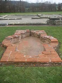 Photographie d'un bassin antique à la margelle en briques.