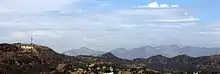 panorama de montagnes avec des habitations dans la vallée, d'une antenne radio et des lettres HOLLYWOOD au sommet de celles de gauche