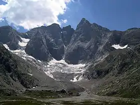Photographie d'un massif montagneux en partie enneigé.