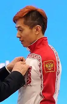 Ahn Hyun-soo de profil, portant une veste rouge et blanche.