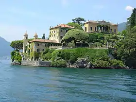 Photo d'une riche villa arborée près d'un lac.