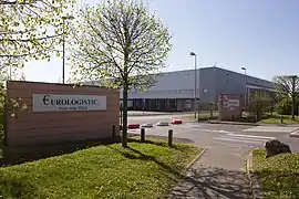 vue d'un bâtiment industriel de couleur grise et d'un portail d'entrée en brique