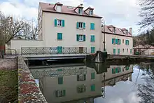 Vue d'une maison construite à cheval sur une rivière.