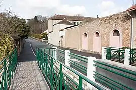 Vue d'une route à la sortie d'un pont ; bâtiments sur la droite.