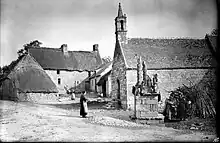 Le village de Bonigeard avec son calvaire, sa chapelle et trois villageoises vaquant à leurs occupations vers 1911.