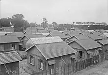 Photographie en noir et blanc d'un ensemble de cabanes en bois.