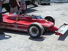 Photo d'une Ferrari 312 T5 dans un stand.