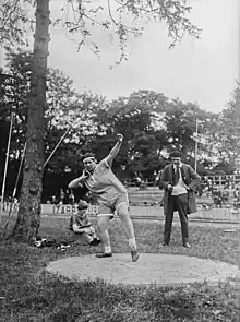 Violette Morris, un poids dans la main, prend de l’élan avant de lancer.