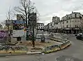 L'entrée du chantier avec un panneau présentant le projet. Vue sur le croisement de la rue des Trois-Mages et de la rue Saint-Michel.