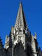 La flèche octogonale vue en contre-plongée depuis la façade méridionale. À l'angle sud-ouest, escalier d'accès à la chambre des cloches et à la balustrade flamboyante.