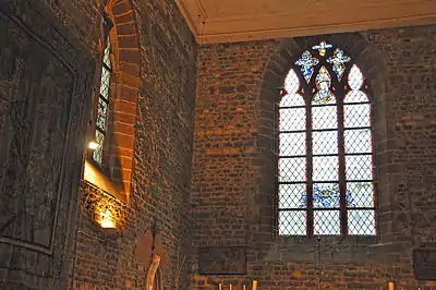 Dans la grande fenêtre ogivale les armoiries du baron de Launoit avec, dans la partie supérieure, un motif religieux représentant la Sainte Trinité. Dans la fenêtre à gauche de l'autel, les armoiries de la comtesse de Limburg Stirum et celle du baron Snoy.
