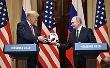 Vladimir Poutine offrant à Donald Trump un ballon Telstar Mechta, le ballon officiel de la phase à élimination directe de la Coupe du monde de football 2018.
