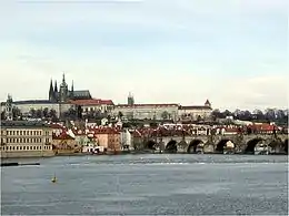 Photographie en couleurs du Hradčany de Prague avec la Vltava qui coule au premier plan