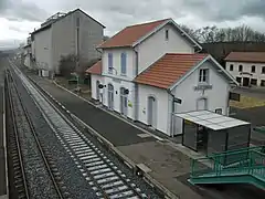 Les deux voies de la gare à gauche, en direction de Clermont-Ferrand, et le bâtiment voyageurs à droite