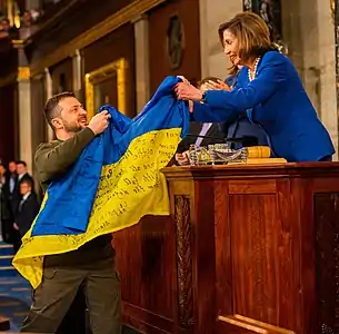 Volodymyr Zelensky lors du discours au Congrès américain, le 22 décembre 2022, transmettant le drapeau de l'Ukraine des combattants de Bakhmout