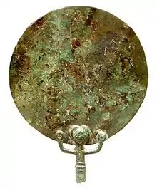 Vue de la partie supérieure d'un miroir en bronze avec un personnage en partie basse