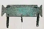 Petite tabula ansata portant une inscription votive en grec à Sérapis. Objet romain de la période impériale.