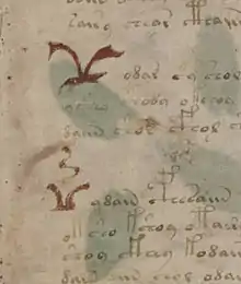 manuscrit : détail de la première page où apparaissent deux grands symboles rouges.